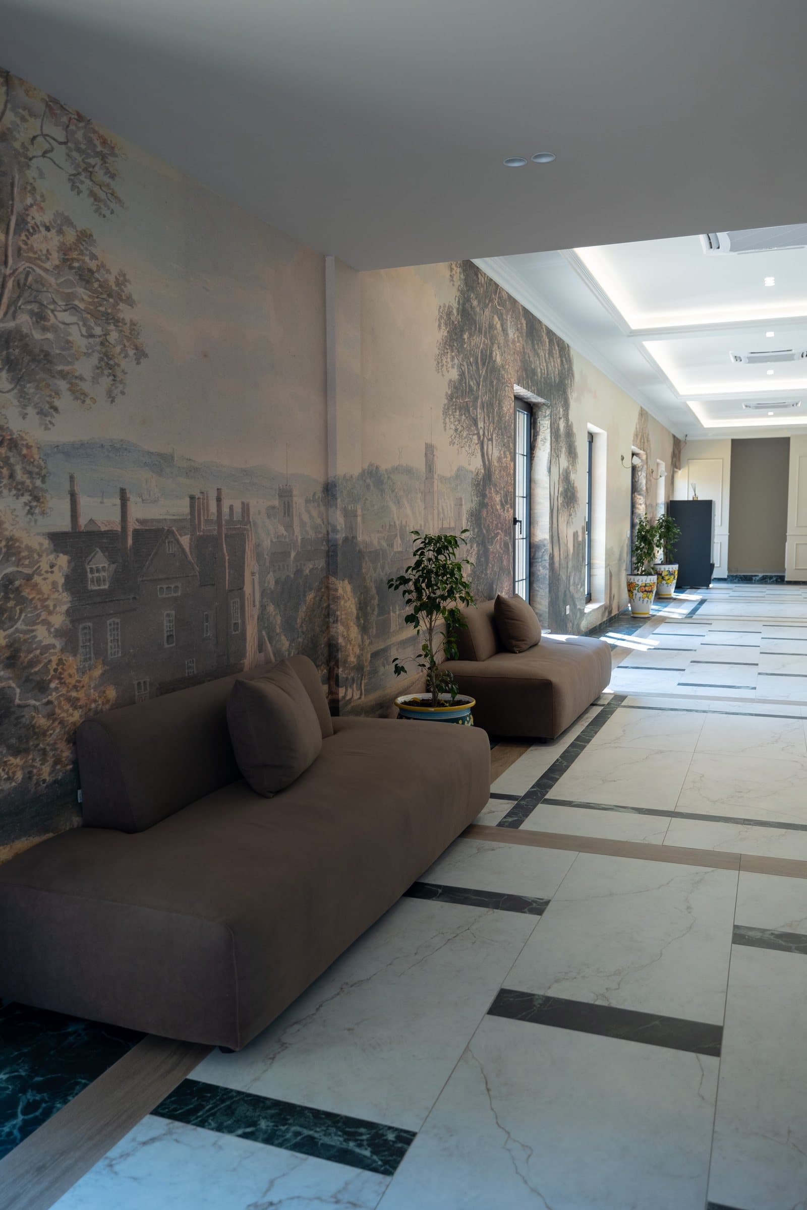 Holli me divan dhe mural peizazhi.